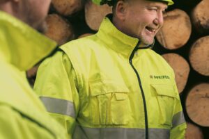 Mitarbeiter vor dem Rundholzlager bei Pfeifer